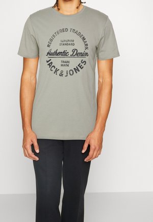 Grijs katoenen T-shirt met een zwarte grafische print in een cirkel met de tekst "Registered Trademark," "Authentic Denim," en "Jack & Jones." Korte mouwen.
