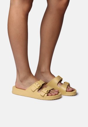 Yellow synthetic slide sandals with two side buckles, flat sole, and open toe design, featuring a smooth texture and a minimalist style.