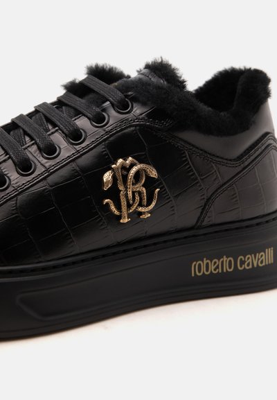 Basket noire en cuir texturé, doublure en fourrure noire, logo serpent doré sur le côté et "roberto cavalli" imprimé en doré sur la semelle.