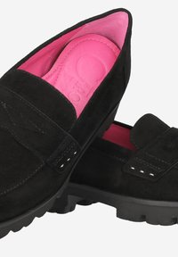 Mocassins en suede noir avec une doublure rose, dotés d'une semelle intérieure en cuir texturé et d'une semelle extérieure en caoutchouc avec des motifs de bande de roulement visibles.