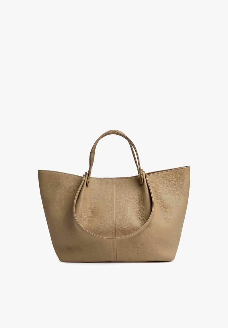 Sac fourre-tout en cuir beige avec une surface texturée, deux poignées arrondies en haut et une ouverture en haut. Le design présente une silhouette large et spacieuse.