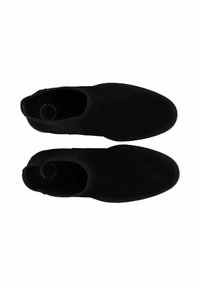 Botines de ante negros que presentan una punta redondeada, paneles laterales elásticos y una textura suave. Sin hardware ni patrones visibles.