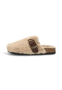 Zueco de felpa beige con un acento de hebilla marrón y una plantilla de corcho texturizada con una suela de goma negra.