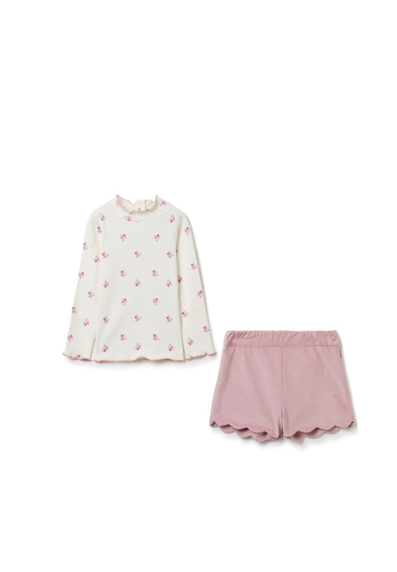 Langärmliges Oberteil in Creme mit pinkem Blumenmuster und Rüschensaum; kombiniert mit pinken Shorts mit gewelltem Saum. Glatte Textur, lässiges Design.