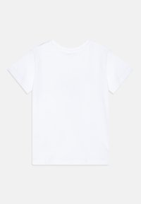 Camiseta blanca de algodón con mangas cortas. Presenta un cuello redondo y una textura suave. Sin logos ni patrones visibles en la parte posterior.