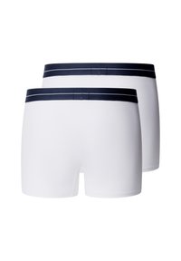 Dos pares de bóxers blancos de hombre con cinturillas elásticas negras apilados sobre un fondo blanco.