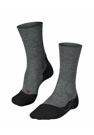 Chaussettes grises à côtes avec des accents noirs au niveau des orteils et du talon. Présente un petit logo rouge sur le côté. Fabriquées en tissu doux et durable.