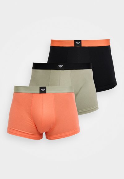 Três pares de cuecas boxer masculinas em preto, verde-oliva e coral. Feitas de tecido macio com cinturas elásticas contrastantes e etiquetas de marca.