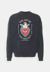 Svart sweatshirt med rund hals. Bakre design visar en färgglad illustration av en kerub och ett hjärta med ett öga, omgiven av text.