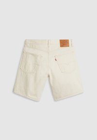 Short en denim écru avec poches arrière, passants pour ceinture et un patch en cuir marron de la marque Levi's sur la ceinture.