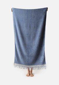 Manta de algodón a rayas azul y blanca con bordes con flecos, forma rectangular, superficie texturizada y borlas en la parte inferior.