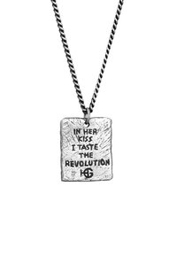 Silverpendant på en vriden kedja, med ett ingraverat citat omgiven av en strukturerad kant. Fyrkantig form med en polerad yta.