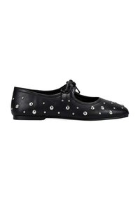 Zapato plano de cuero negro con tachuelas redondas de plata y un pequeño lazo en la parte superior, visto de lado sobre un fondo blanco.