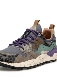 Sneakers multicolori che presentano una combinazione di materiali grigi, marroni e verdi. Gli accenti texture includono una stampa leopardata e una suola viola.