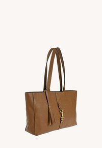 Sac fourre-tout en cuir marron avec deux longues poignées, présentant un détail de pompon et des accents en métal doré. Texture lisse et forme rectangulaire.
