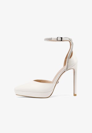 Scarpa con tacco alto piattaforma color bianco, punta a punta e cinturino alla caviglia decorato con piccoli strass e fibbia metallica.