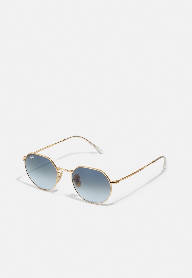 Gafas de sol octagonales con lentes azules degradados, montura de metal dorado y acentos plateados en las patillas. Piezas de plástico transparente en las orejas.