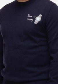 Maglione navy con scollatura a girocollo, dotato di testo ricamato "Il tempo è denaro" e un grafico di un orologio sul lato superiore sinistro.