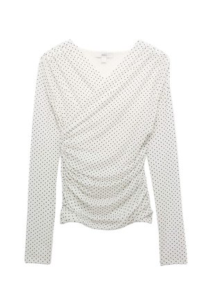 Top blanco de manga larga con lunares negros, detalle fruncido en la parte delantera y escote en V.