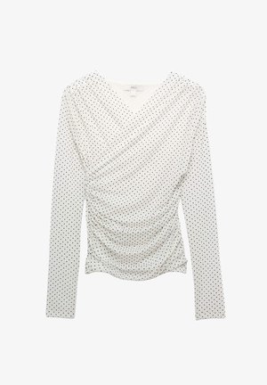 Bílý top s dlouhým rukávem s černými puntíky, s nabráním vpředu a výstřihem do V.