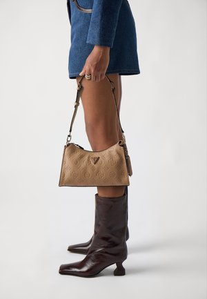 Beige-texturoitu laukku, jossa on kohokuvioituja kuvioita, kaareva muotoilu, säädettävä olkahihna, yhdistetty ruskeisiin polviin saakka ylettyviin saappaisiin, joissa on neliönmuotoinen kärki.