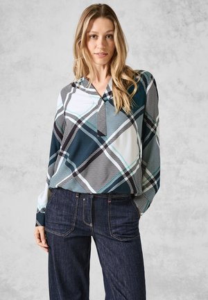 Blouse à manches longues multicolore avec un motif géométrique en bleu sarcelle, noir et blanc. Tissu léger ; coupe décontractée avec un décolleté en V.