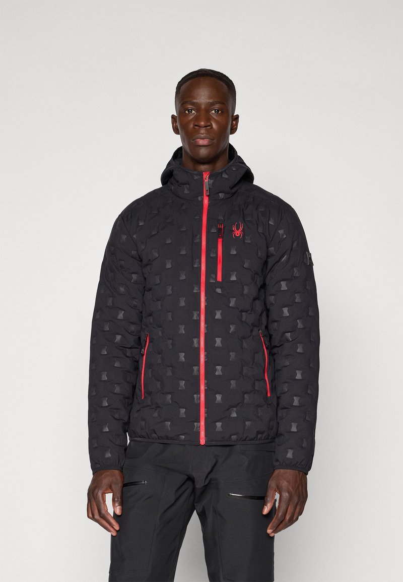 Black puffer jacket with a patterned texture, red zippers, and logo detail on the chest. Features a hood and zippered side pockets.