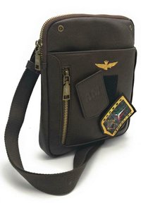 Borsa a tracolla in pelle marrone con accenti dorati, dotata di una tasca frontale con zip, una tracolla in tessuto e toppe decorative sul davanti.