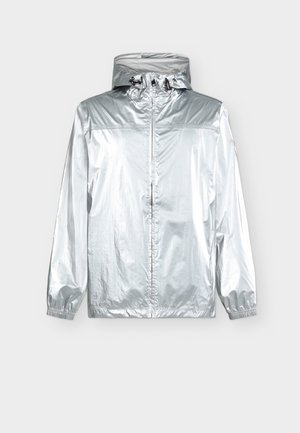 Silberne Regenjacke mit Kapuze, Frontreißverschluss, elastischen Bündchen und verstellbaren Kordeln an der Kapuze, vor einem einfarbigen Hintergrund präsentiert.