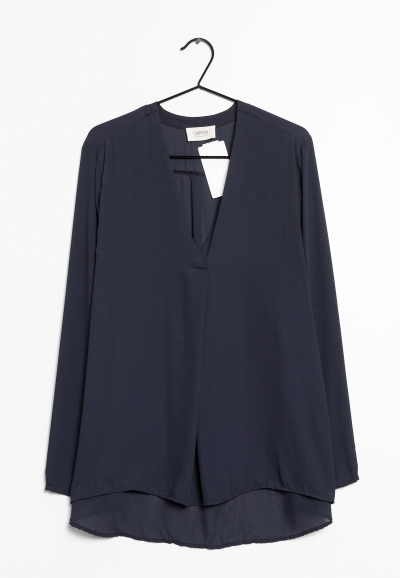 Blusa navy a maniche lunghe realizzata in tessuto leggero, caratterizzata da un profondo scollo a V, una vestibilità ampia e un design orlo alto-basso.