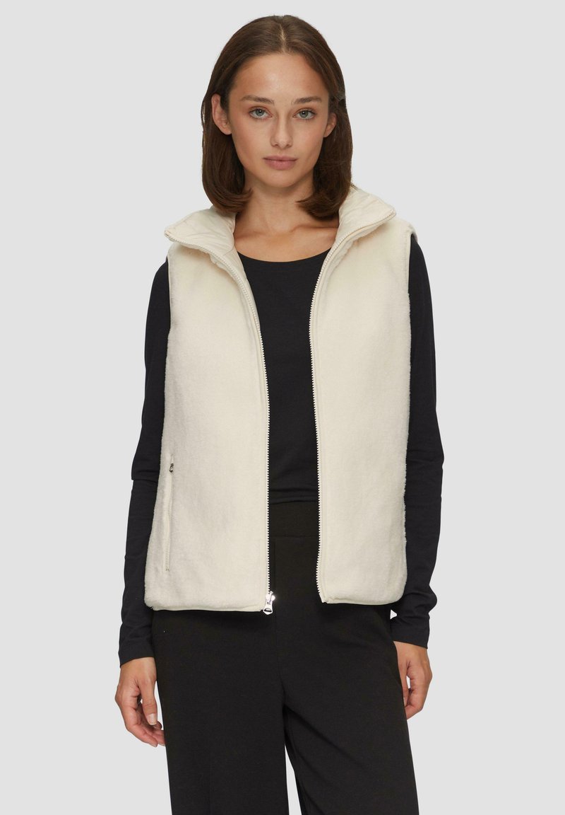 Kamizelka polarowa w kolorze off-white z wysokim kołnierzem i pełnym zamkiem z przodu, z bocznymi kieszeniami i miękkim, teksturowanym wykończeniem.