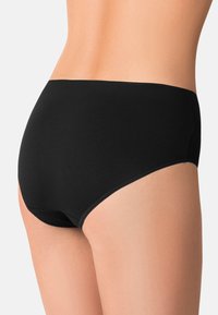 Slip in cotone nero con una texture liscia e una vita elastica, progettato per una vestibilità sicura e una copertura completa sul retro.