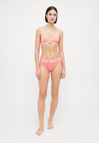Pink bikini set featuring a bralette with a textured pattern and matching high-waisted briefs with "Moschino" logo on the waistband.