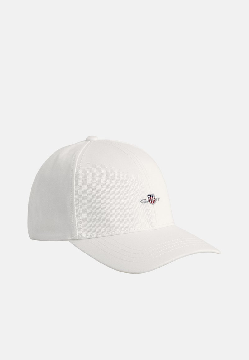 White baseball cap made of smooth fabric, featuring a stitched logo and adjustable back strap. Curved brim with tonal stitching details.