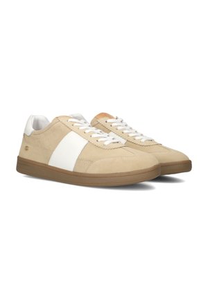 Beige suède sneakers met een witte leren streep, witte veters en een rubberen zool met een gestructureerd patroon.