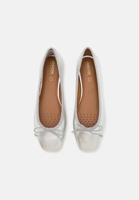 Ballerine in pelle argentata con punta arrotondata, dettaglio a fiocco sulla parte anteriore e soletta perforata per traspirabilità. Fodera interna marrone.