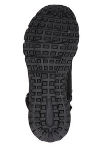 Suela de zapato de goma negra con un patrón de cuadrícula texturizado que presenta cuadrados y líneas elevadas para mayor tracción. Se pueden ver el tacón redondeado y los bordes curvados.