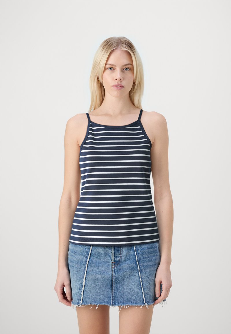 Navy-blau gestreifes Tanktop mit dünnen Trägern und rundem Ausschnitt, kombiniert mit einem Denim-Minirock mit ausgefransten Kanten.
