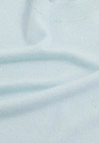 Helles blaues Strickpullover, weiche Textur, Rundhalsausschnitt, subtile Rippung an den Kanten, glattes Gewebe ohne Muster oder Hardware-Details.