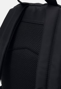 Černý batoh s polstrovanou texturovanou mřížkovou zadní panelou, vyztuženými okraji a odolným textilním povrchem.