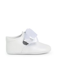 Zapato de cuero blanco con bordes ondulados, que presenta un lazo ancho de cinta blanca en la parte delantera. Punta redondeada y costura elástica en los laterales para un mejor ajuste.