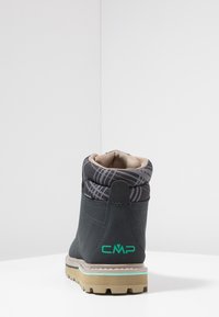 Mørkeblå ankelstøvle med et mønstret sort og gråt manchet, gummisål og CMP-logo i grøn på hælen, samt syninger som detalje.