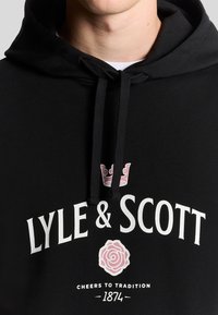 Felpa con cappuccio nera caratterizzata da una grafica frontale con "LYLE & SCOTT" in bianco, una corona rosa e un motivo floreale. Realizzata in cotone, vestibilità casual.
