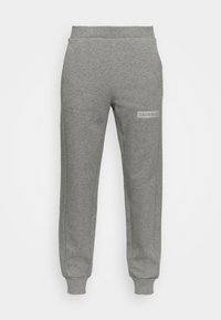 Pantalones de chándal grises con cintura elástica, bolsillos laterales y un parche rectangular con el logo en el muslo izquierdo. Fabricados con una suave mezcla de algodón.