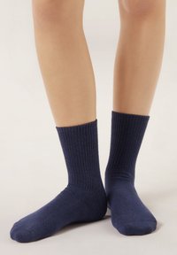 Calcetines azul marino acanalados con una textura suave, de longitud media hasta la pantorrilla, con puntera sin costuras y puño ajustado para mayor comodidad y estilo.