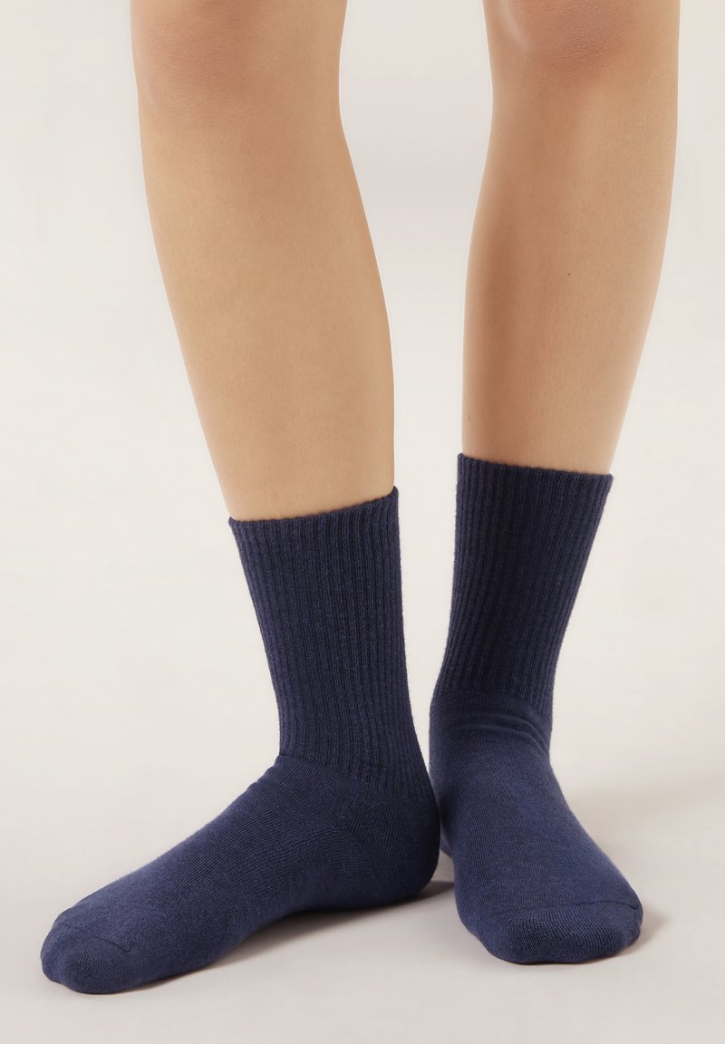 Calcetines azul marino acanalados con una textura suave, de longitud media hasta la pantorrilla, con puntera sin costuras y puño ajustado para mayor comodidad y estilo.