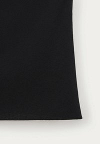 Tissu tricoté noir avec une texture fine visible et un bord droit sur fond gris clair.