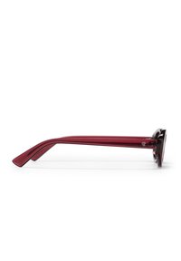Κόκκινα πλαστικά γυαλιά ηλίου με κομψό σχεδιασμό, που διαθέτουν κυρτό βραχίονα και γυαλιστερό φινίρισμα. Εμφανές λογότυπο στο πλάι.