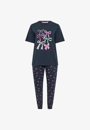 Marineblaues Kurzarm-Top mit pastellfarbenen Schleifendrucken kombiniert mit marineblauen Hosen, die mit kleinen rosa Schleifenmustern bedeckt sind.