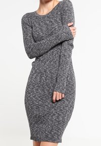 Robe à manches longues grise côtelée avec une silhouette ajustée, en tissu tricoté texturé, avec un large décolleté et une longueur mi-cuisse.